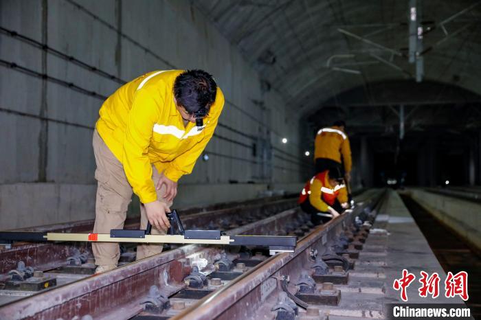 中國鐵路南寧局集團(tuán)有限公司南寧工務(wù)段職工使用道尺檢查吳圩機(jī)場高鐵站高鐵線路設(shè)備?！№f剛 攝